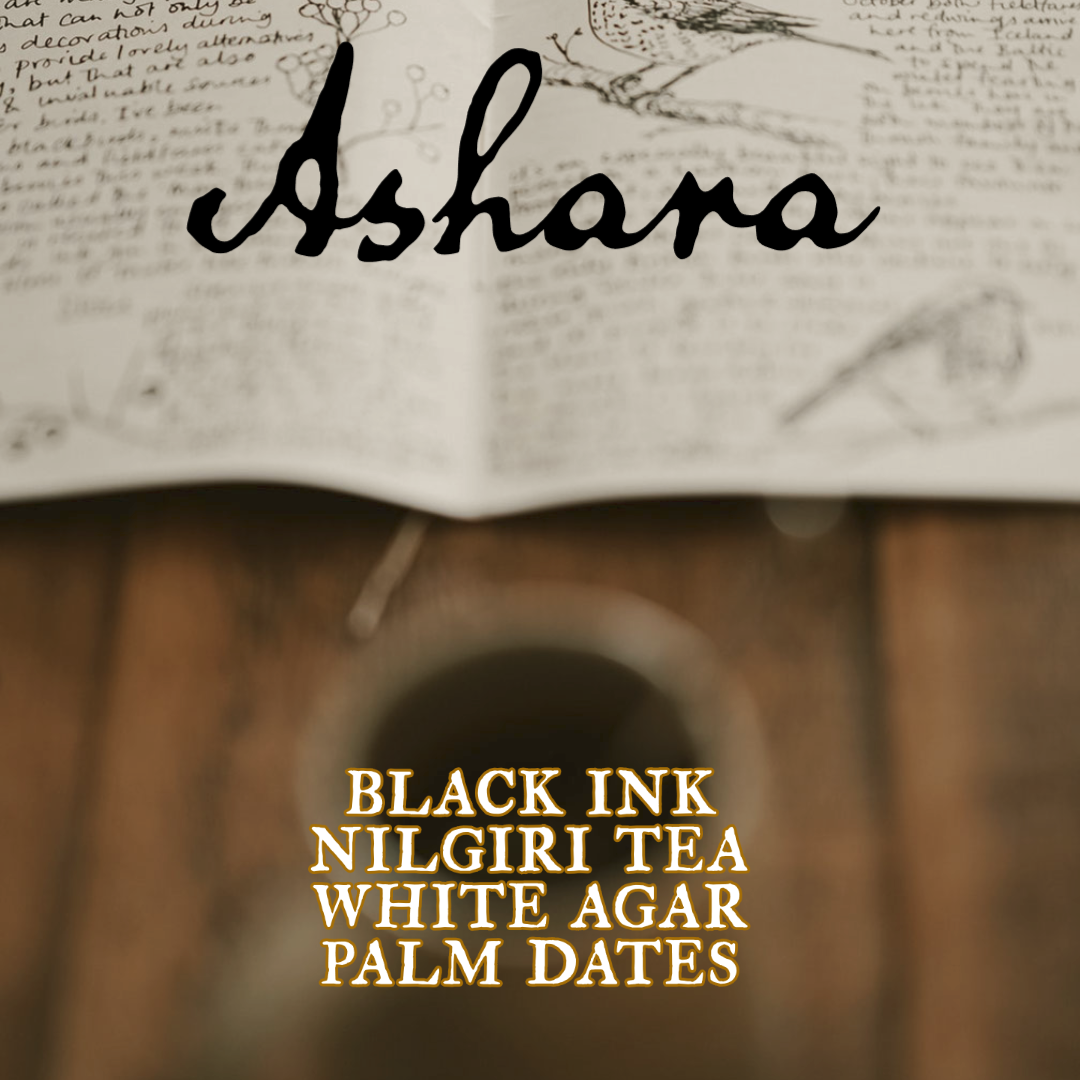 Ashara, black ink, nilgiri tea, white agar, palm dates. The image shows an out of focus cup of tea in the foreground with a  handwritten document in the background.